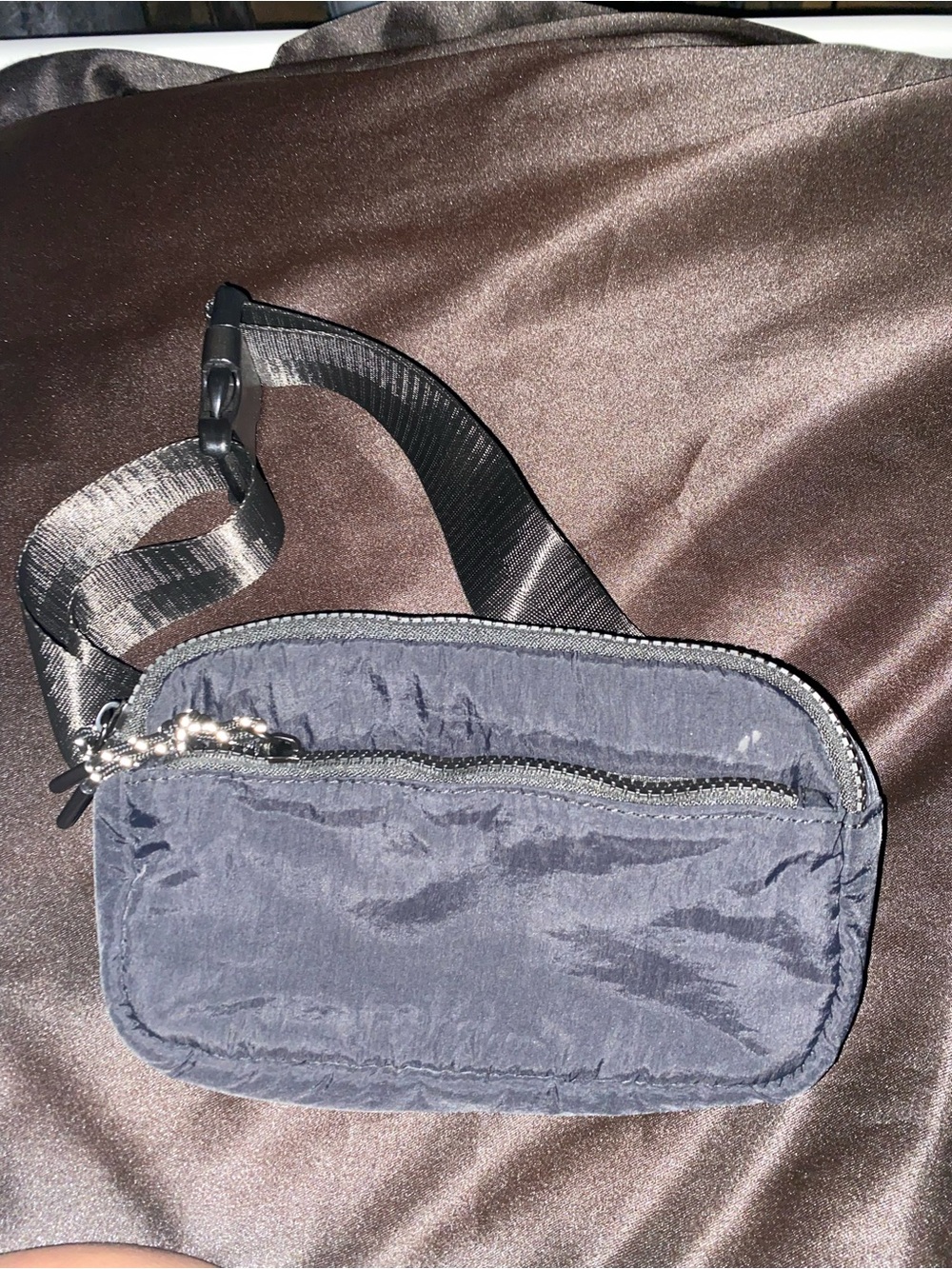 Black nylon belt bag featuring an adjustable strap